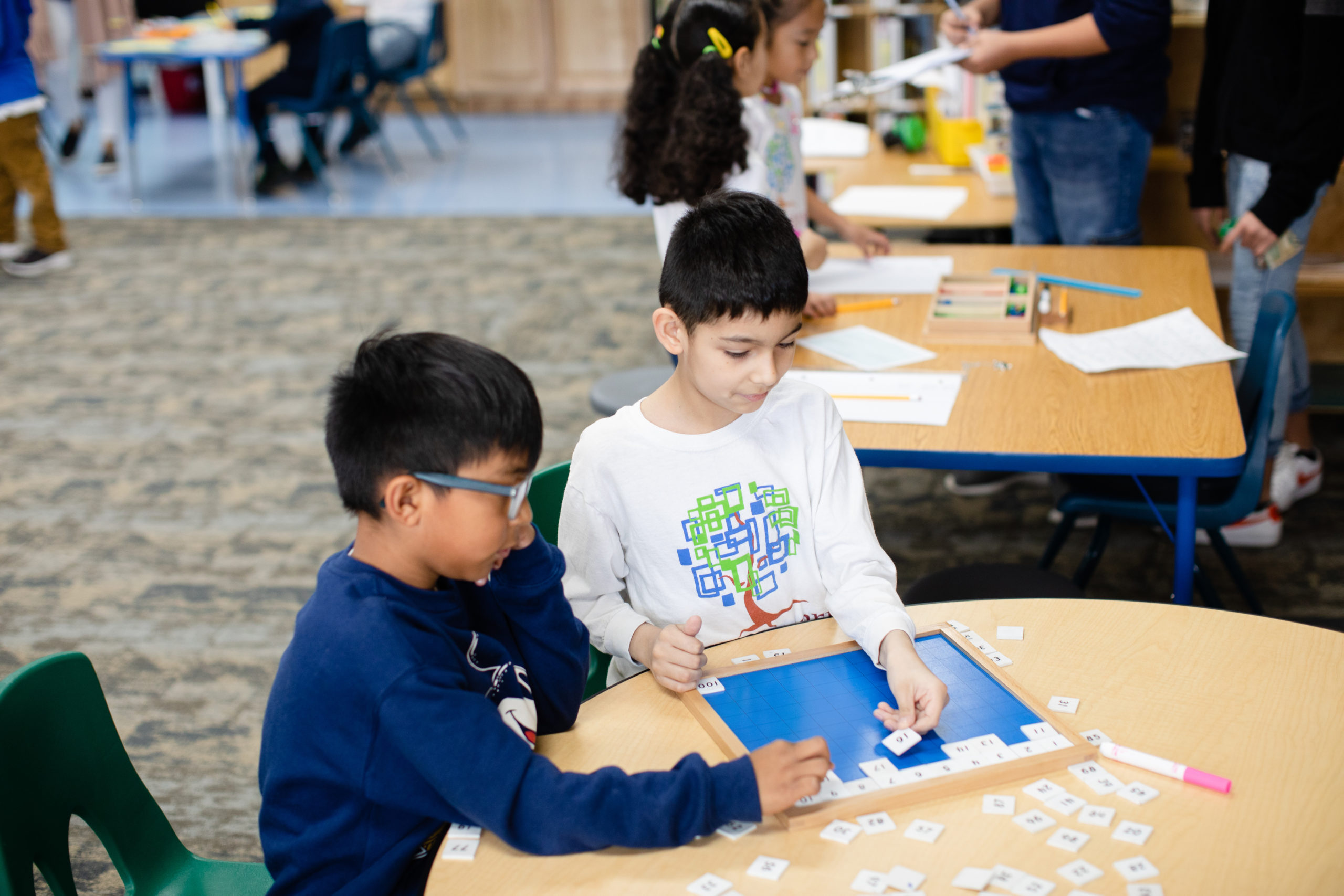 Two young students doing a puzzle.